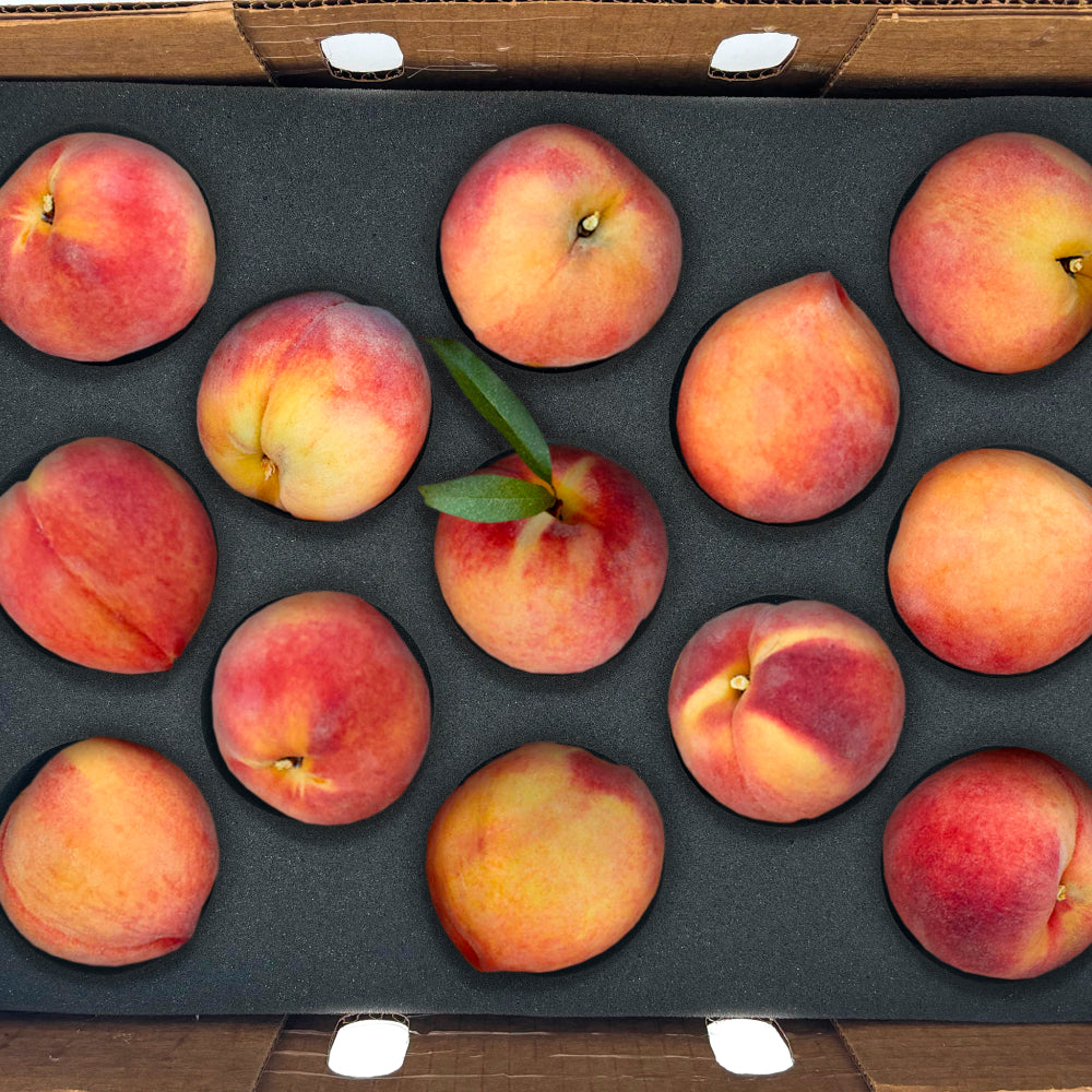 A top down shot of 13 peaches in a box